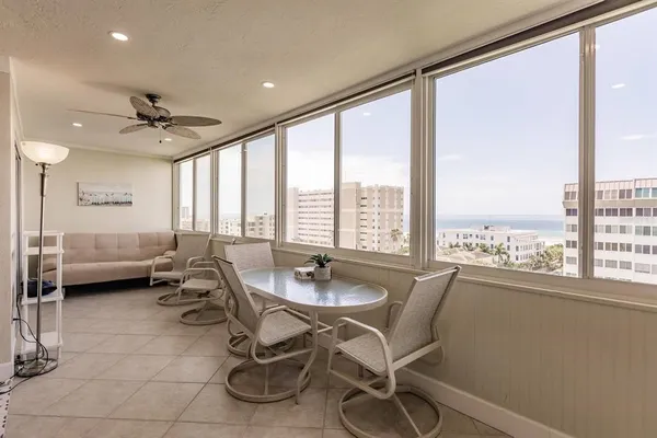 a dining room with furniture and a floor to ceiling window