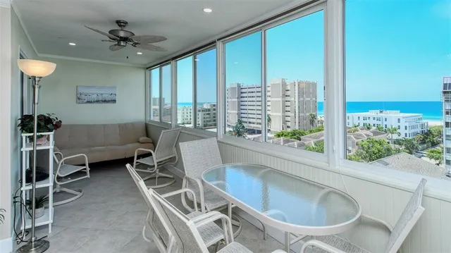 a living room with furniture a ceiling fan and a large window