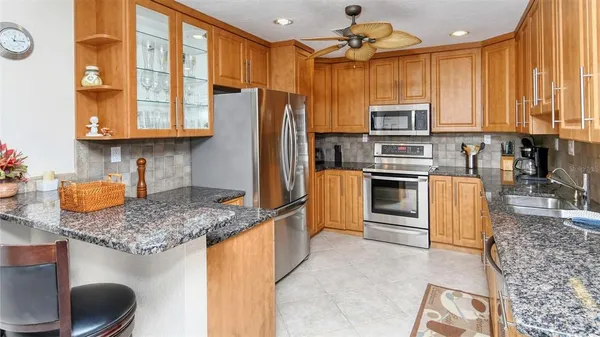 a kitchen with stainless steel appliances granite countertop a stove refrigerator and a sink