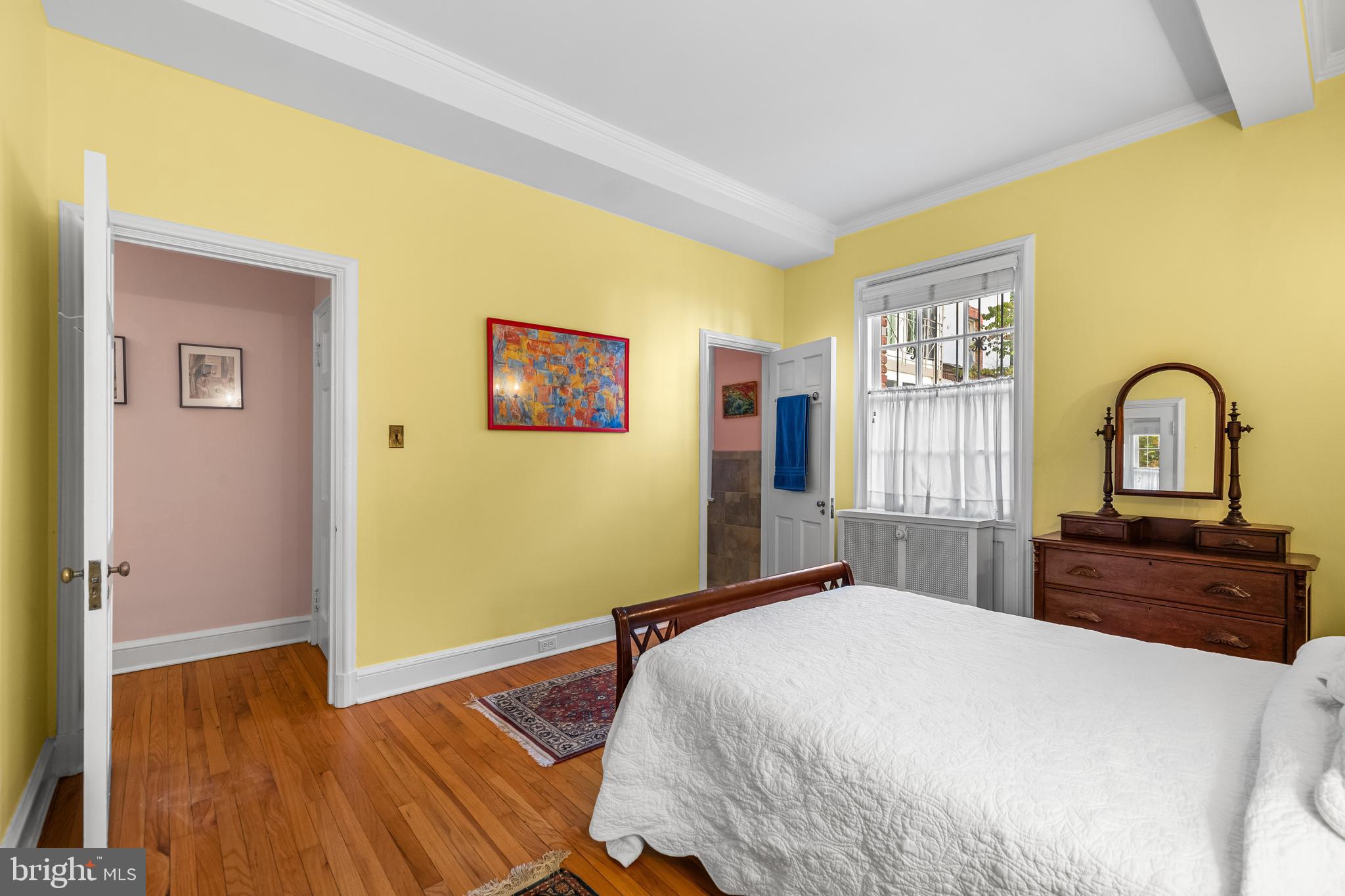 6 Upland Road, Unit F1 Baltimore, MD 21210 - Photo 32 of 50 a bedroom with a bed and a dresser with wooden floor