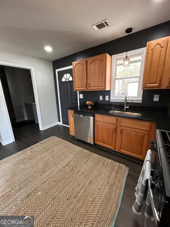 a kitchen with granite countertop sink refrigerator and window