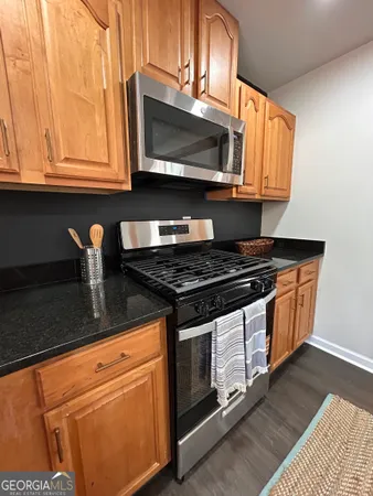 a kitchen with stainless steel appliances granite countertop a stove and a microwave
