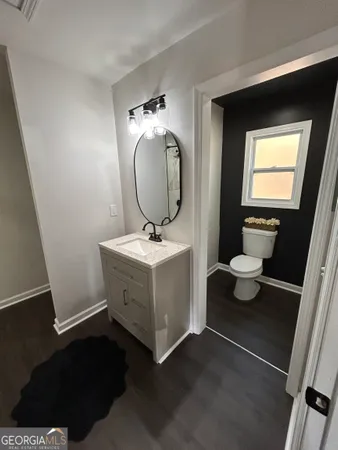 a bathroom with a sink toilet and a mirror