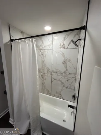 a bathroom with a bathtub and a shower