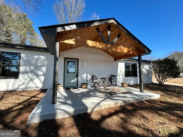 a view of a house with backyard and sitting area