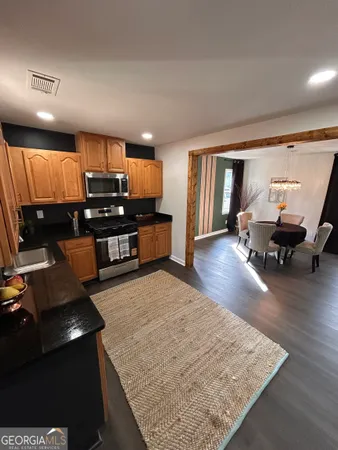 a kitchen with stainless steel appliances kitchen island granite countertop a refrigerator stove and oven