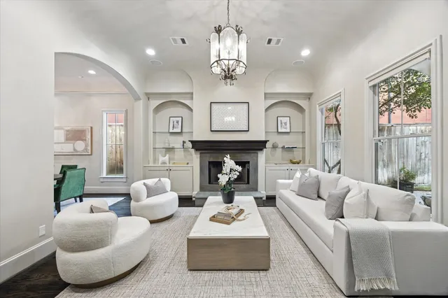 a living room with furniture a large window and a chandelier