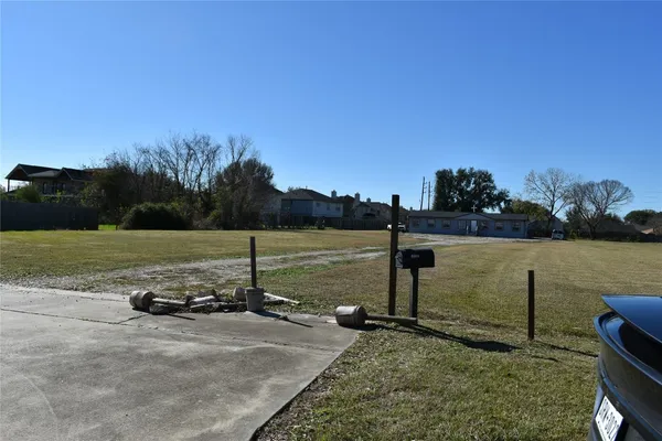 a view of a lake with a yard and large trees