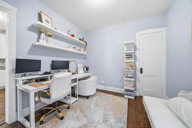 a view of a workspace with furniture and a window