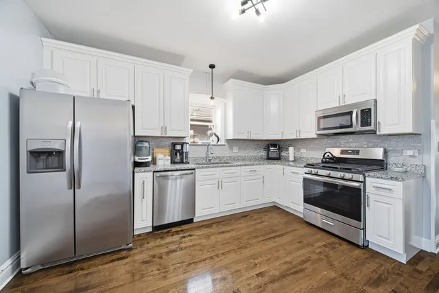 a kitchen with granite countertop a refrigerator stove and microwave