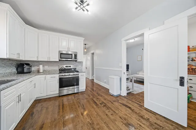 a kitchen with granite countertop a stove top oven a sink and cabinets