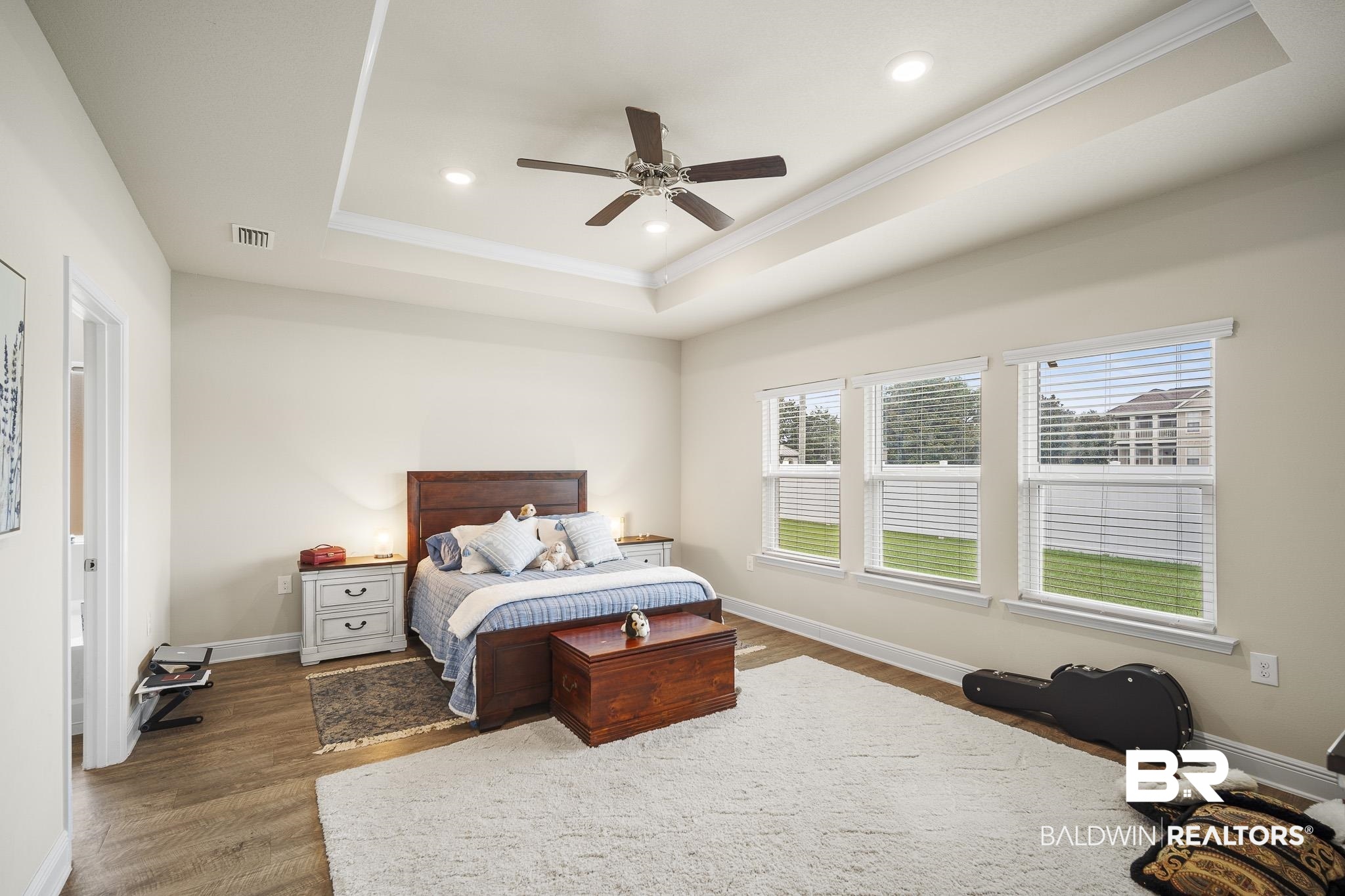 24765 Spectacular Bid Loop Daphne, AL 36526 - Photo 24 of 45 Bedroom featuring dark hardwood / wood-style floors, ceiling fan, a tray ceiling, and crown molding