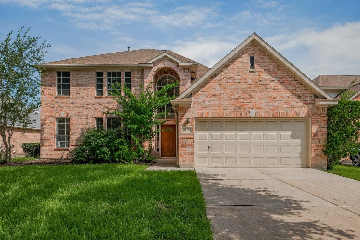 a front view of a house with a garden and plants