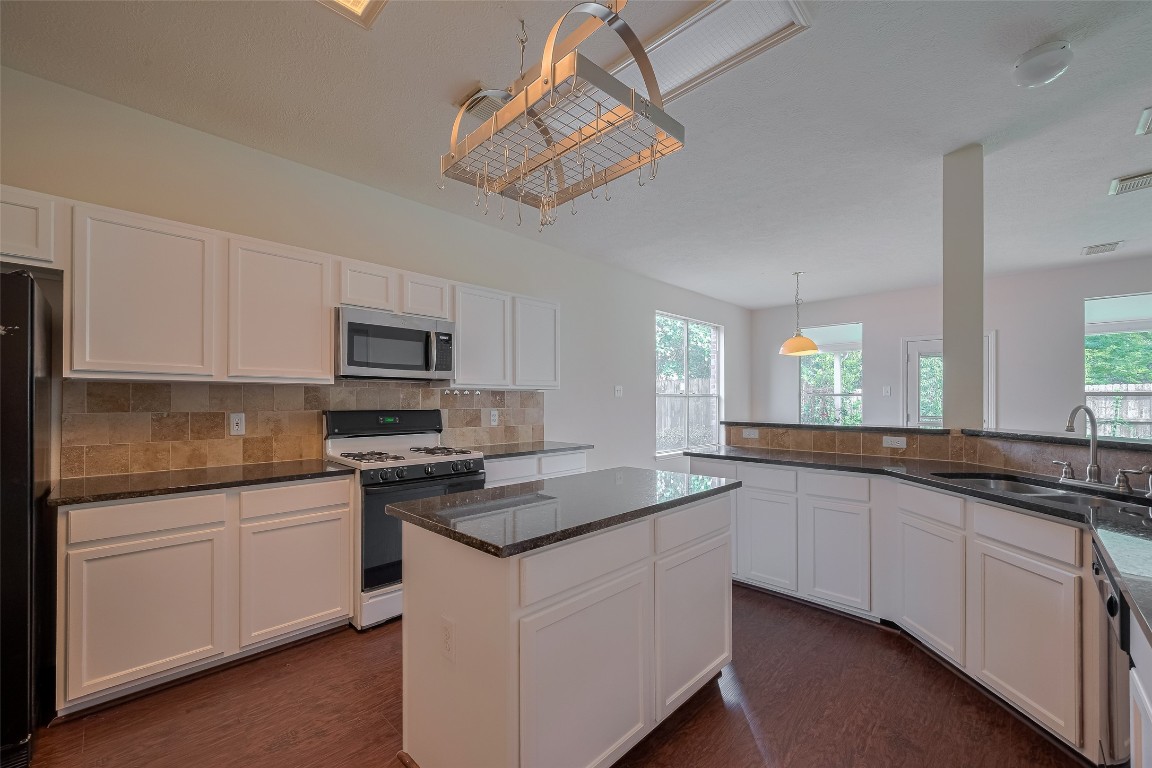 619 Bending Bough Drive Spring, TX 77388 - Photo 12 of 41 a kitchen with stainless steel appliances granite countertop a sink and dishwasher a stove top oven with white cabinets
