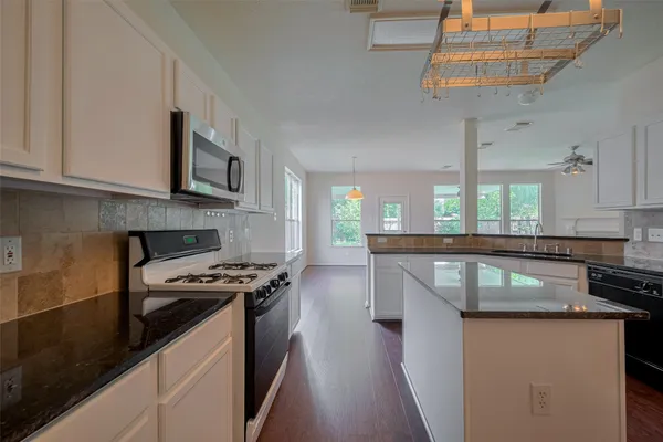 a kitchen with stainless steel appliances granite countertop a sink a stove and a microwave