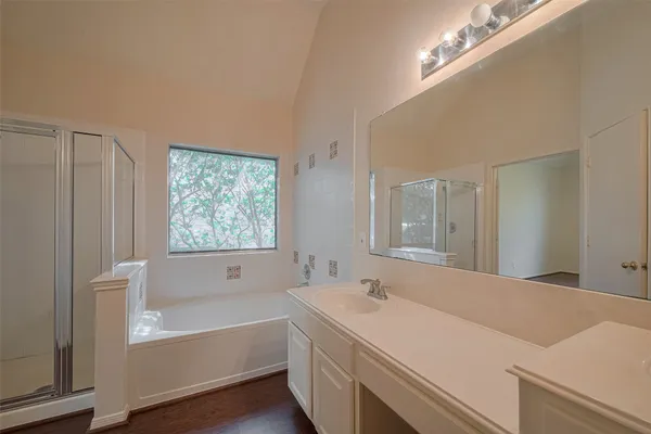a bathroom with a tub a sink and a large mirror