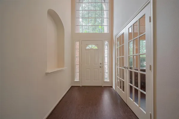 a view of a hallway with wooden floor and entryway