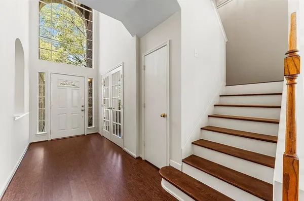 a view of a hallway with wooden floor and entryway