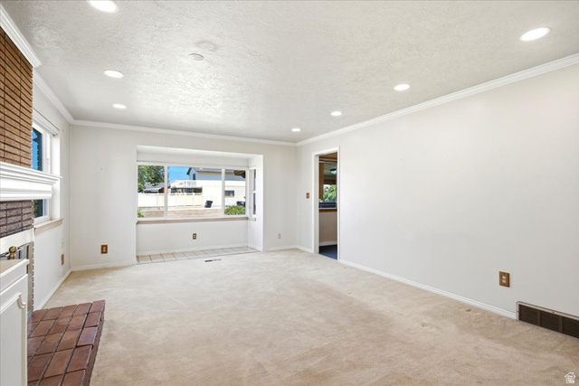 2252 West 800 North Clinton, UT 84015 - Photo 7 of 38 Spacious living area featuring a bay window with tiled flooring, neutral-toned carpet, recessed lighting, and a brick fireplace