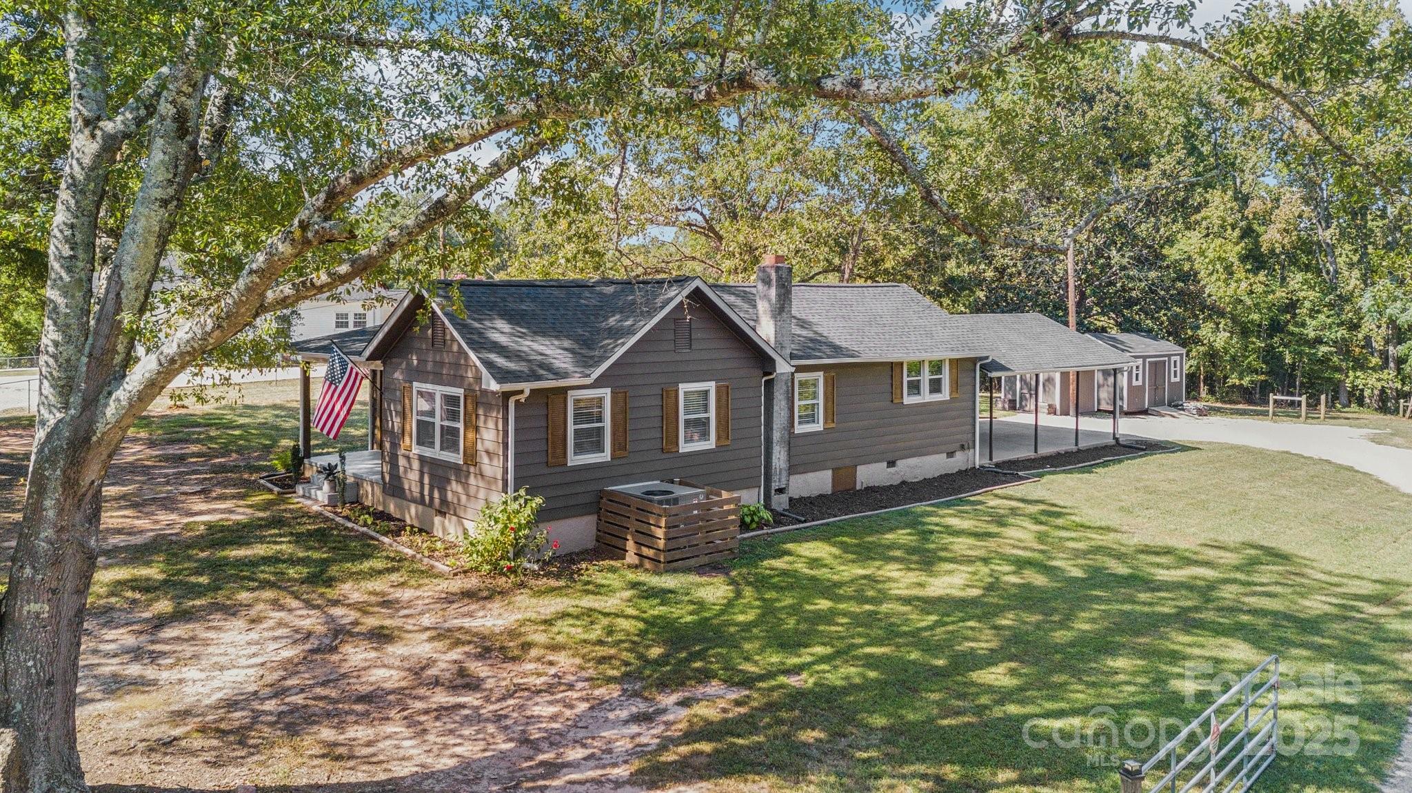 a front view of a house with yard and tree