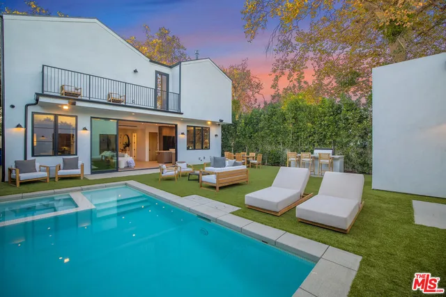 a view of a house with swimming pool and sitting area