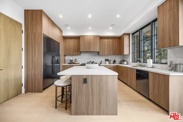 a kitchen with a sink a refrigerator and a stove top oven