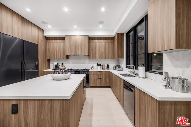 a kitchen with sink a refrigerator and cabinets