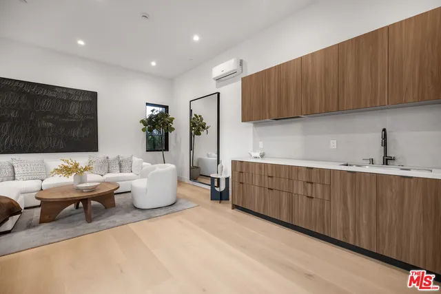 a living room with furniture a wooden floor and a sink
