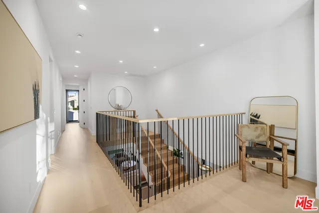 a view of a hallway with wooden floor stairs and a chandelier