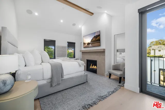 a spacious bedroom with bed and a fireplace