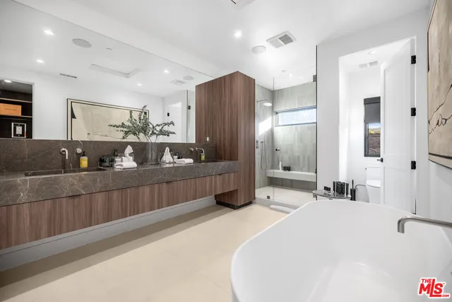 a spacious bathroom with a double vanity sink and mirror