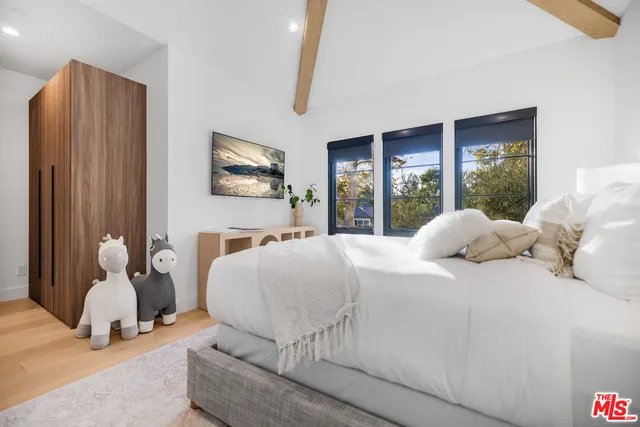 a bedroom with a bed and large windows