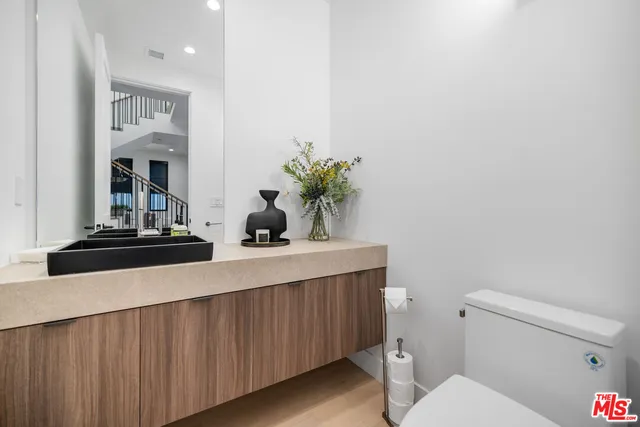 a bathroom with a toilet a sink and mirror