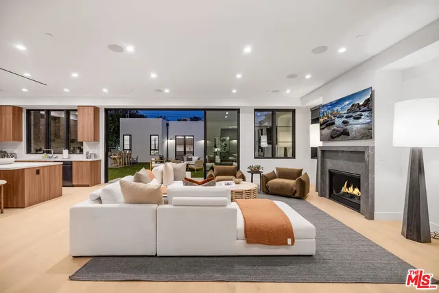 a living room with furniture fireplace and kitchen view