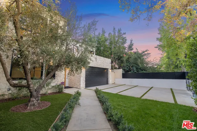 a front view of a house with a garden and yard