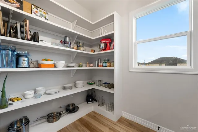 a cabinet with granite countertop lots of different kinds of food