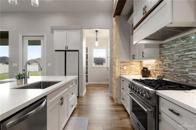 a kitchen with granite countertop a sink stove and refrigerator
