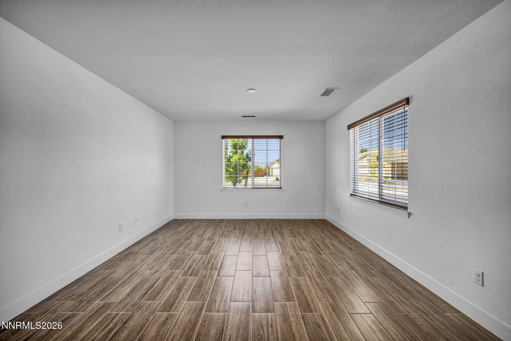 7181 Saddlehorn Road Carson City, NV 89701 - Photo 12 of 62 an empty room with wooden floor and windows