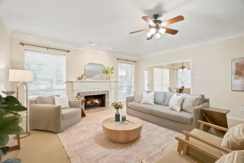 a living room with furniture a fireplace and a large window