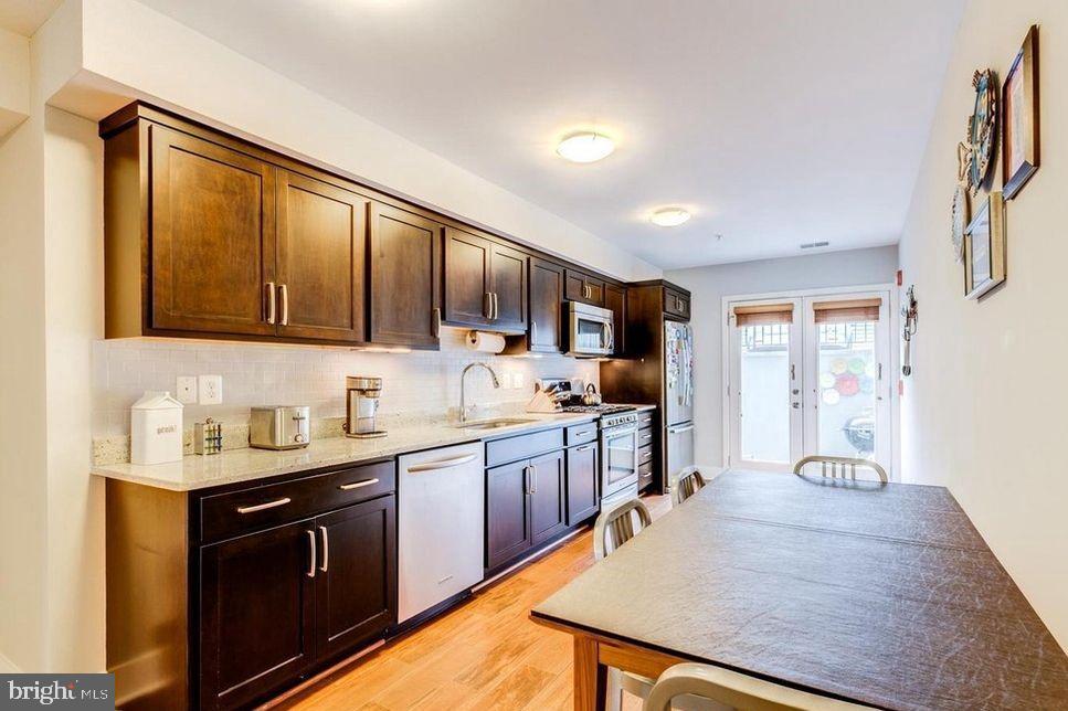 3465 14th Street Northwest, Unit A Washington, DC 20010 - Photo 13 of 28 a kitchen with stainless steel appliances granite countertop a sink stove and refrigerator