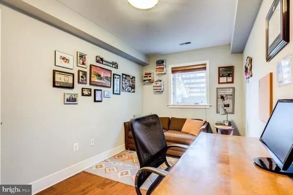 a view of a workspace with furniture and wooden floor