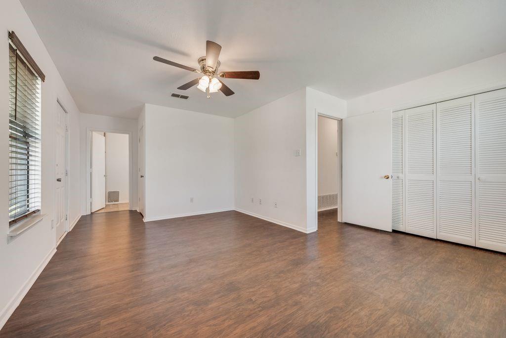 301 Lipscomb Street Cleburne, TX 76031 - Photo 13 of 21 an empty room with wooden floor ceiling fan and windows