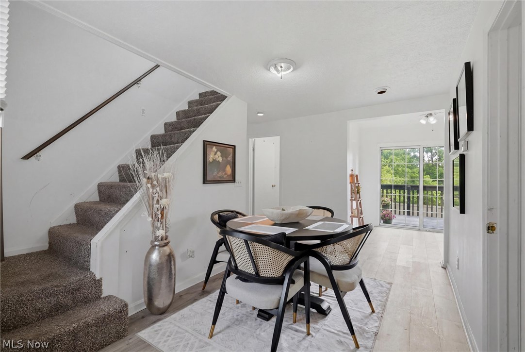 5860 Kirk Road Canfield, OH 44406 - Photo 7 of 17 Dining area featuring wood-finish flooring, a contemporary ceiling light fixture, and direct access to an outdoor deck through sliding glass doors