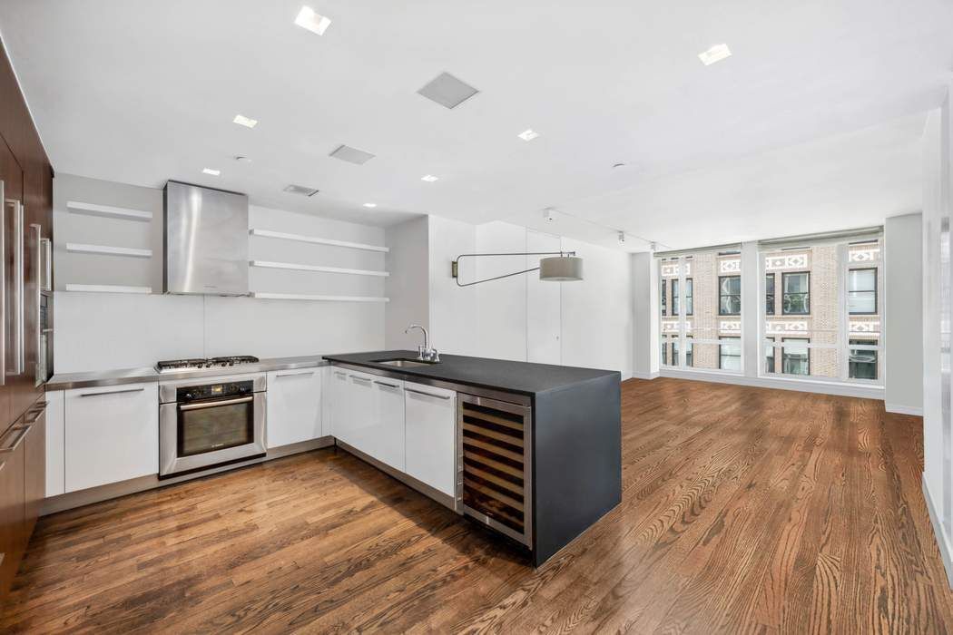 a kitchen with stainless steel appliances granite countertop a stove and a wooden floors
