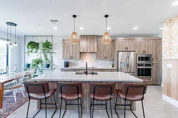a kitchen with granite countertop a table and chairs stainless steel appliances