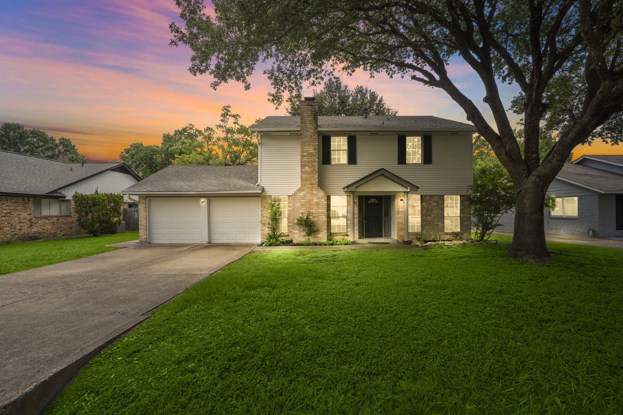 a front view of a house with yard and green space