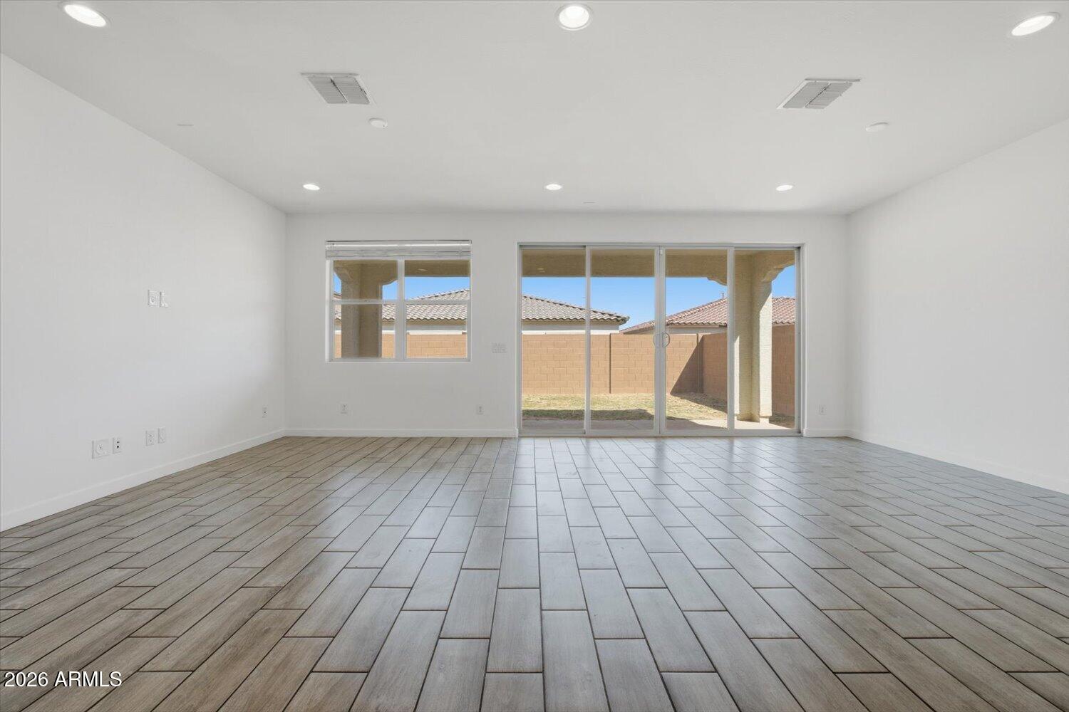 2542 West Pecan Road Phoenix, AZ 85041 - Photo 8 of 30 a view of an empty room with wooden floor and a window