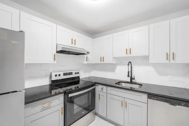 a kitchen with cabinets stainless steel appliances and a sink