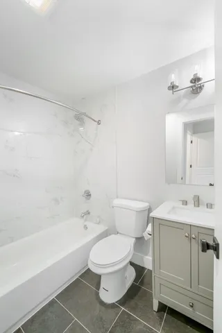 a bathroom with a toilet a sink a mirror and bathtub