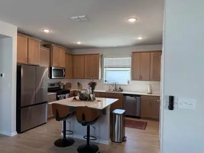 a kitchen with a sink stainless steel appliances and chairs